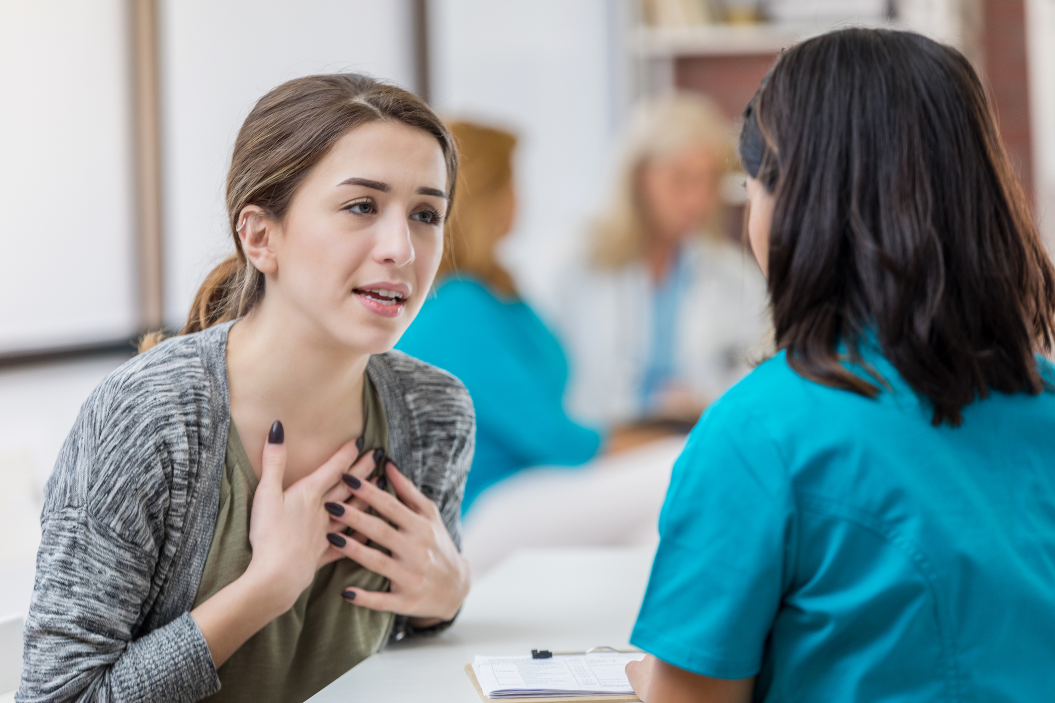 Concerned young female patient talks with healthcare professional